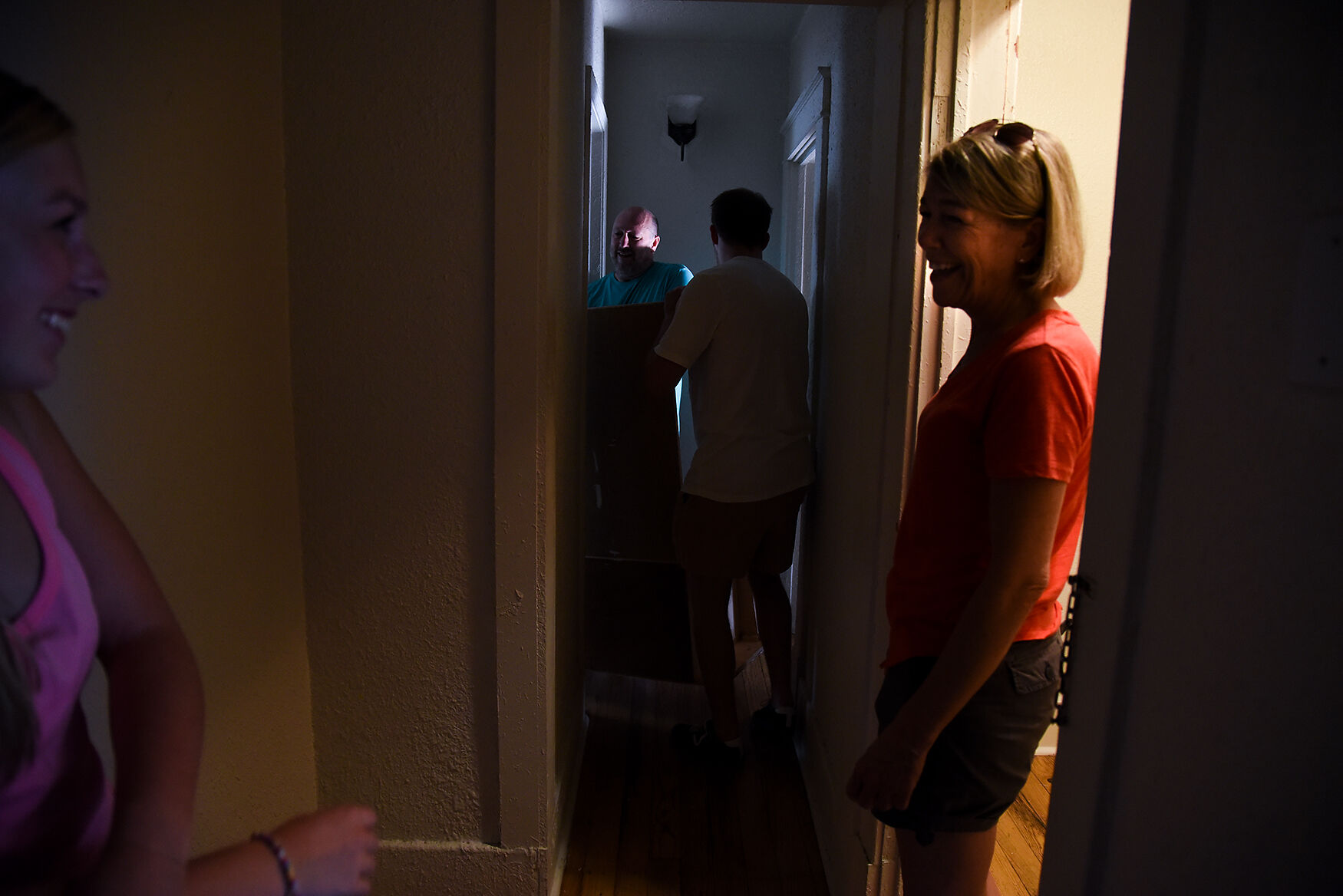 From left, Hannah Owens, John Owens, Max Owens and Julie Owens move a chest of drawers in Hannah's house
